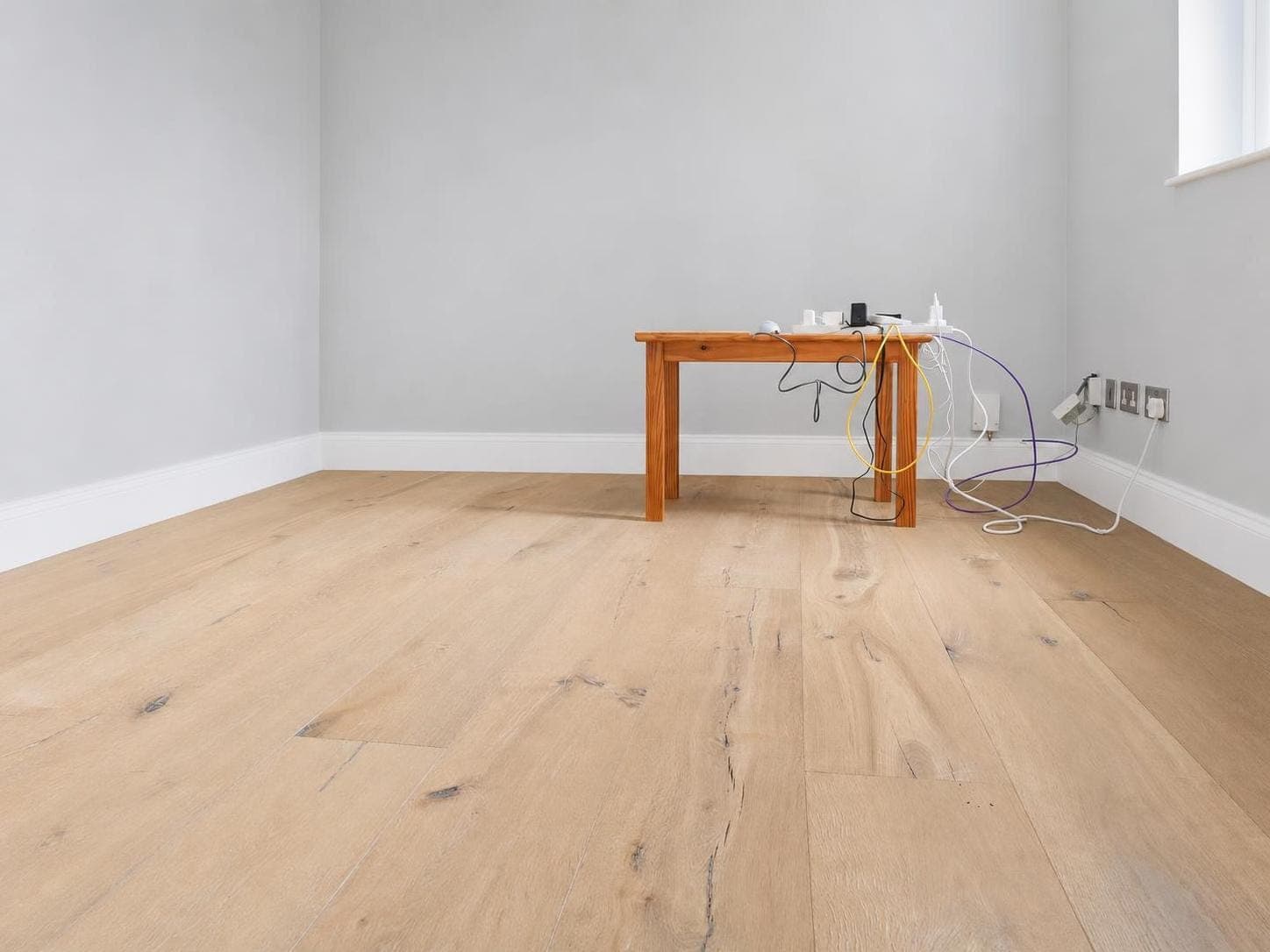 Empty room with white-painted walls, white skirting boards and a grey-painted ceiling